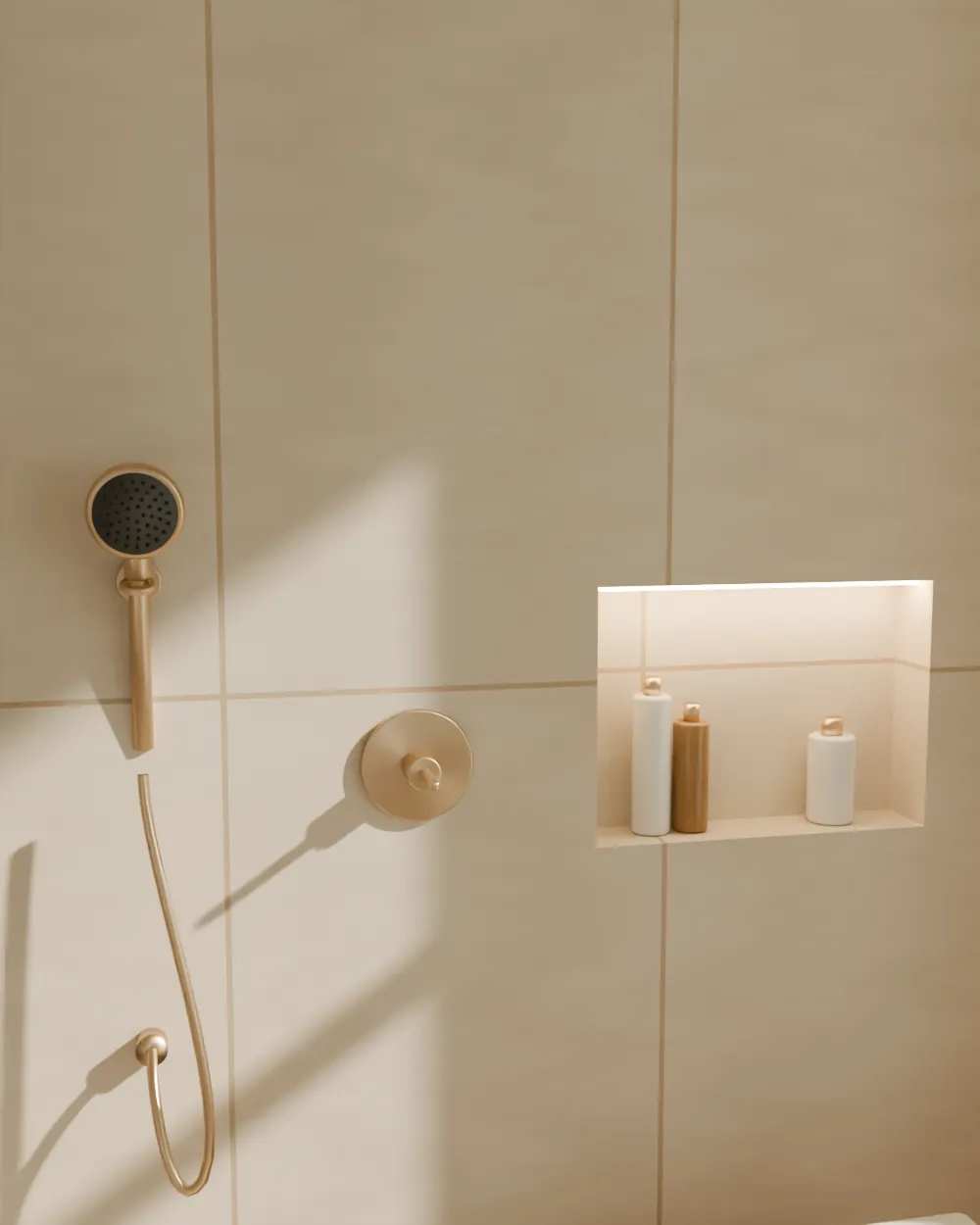 Detail van een douchewand in travertin met een messing handdouche in een wandhouder, een mengkraan en een verlichte nis met flessen.